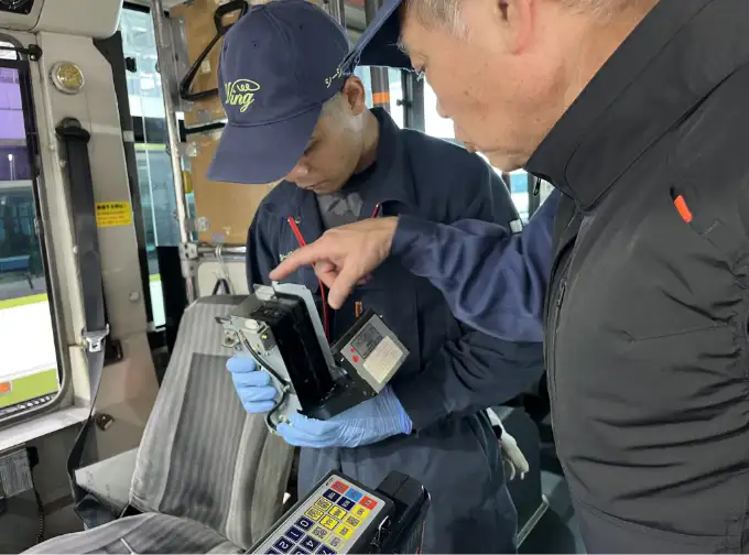運賃箱点検中のベテランと若手